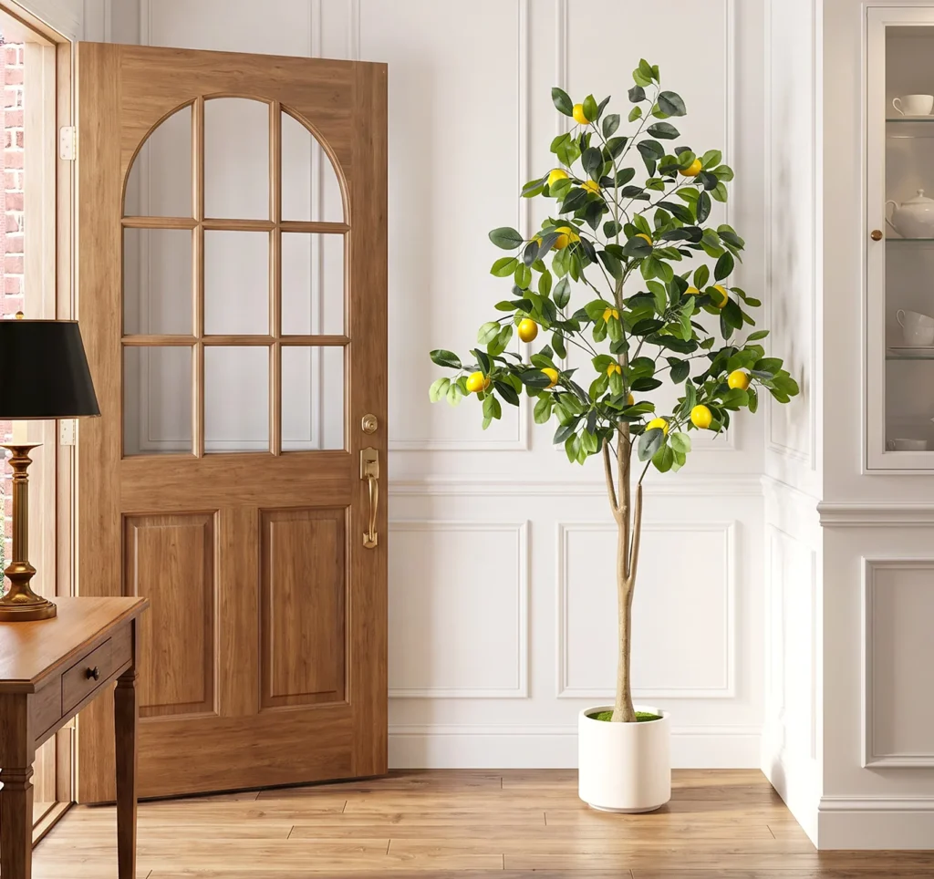 Faux lemon tree in a white planter beside a wooden entryway door